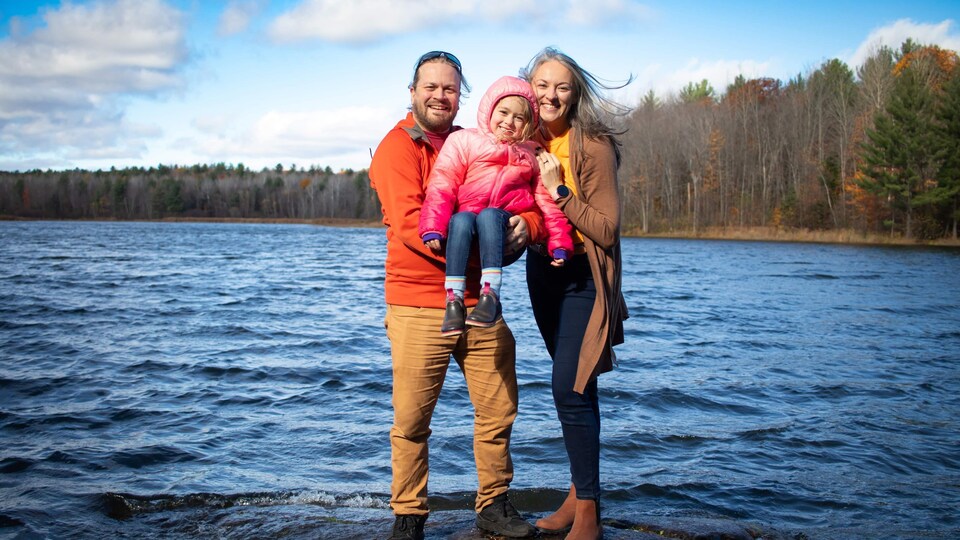 Une famille devant un lac.