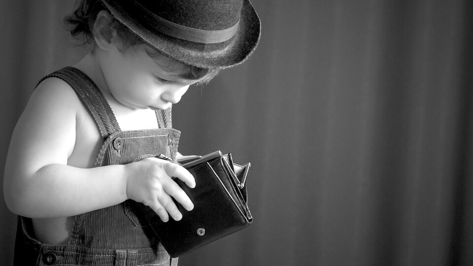 Petit garçon avec un porte-feuille vide.
