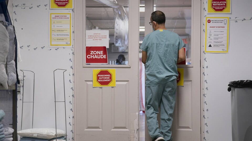 Un travailleur de la santé s'apprête à entrer dans une zone chaude d'un hôpital.