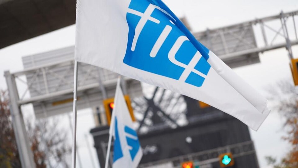 Un drapeau de la FIQ brandi devant le pont de Québec.