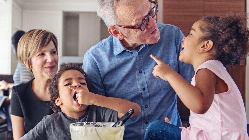 Des grands-parents faisant de la cuisine avec leurs petits-enfants.