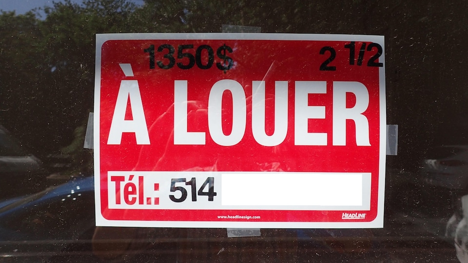 Affiche « À louer » placée dans une fenêtre pour un appartement 2 et demi à 1350 $.