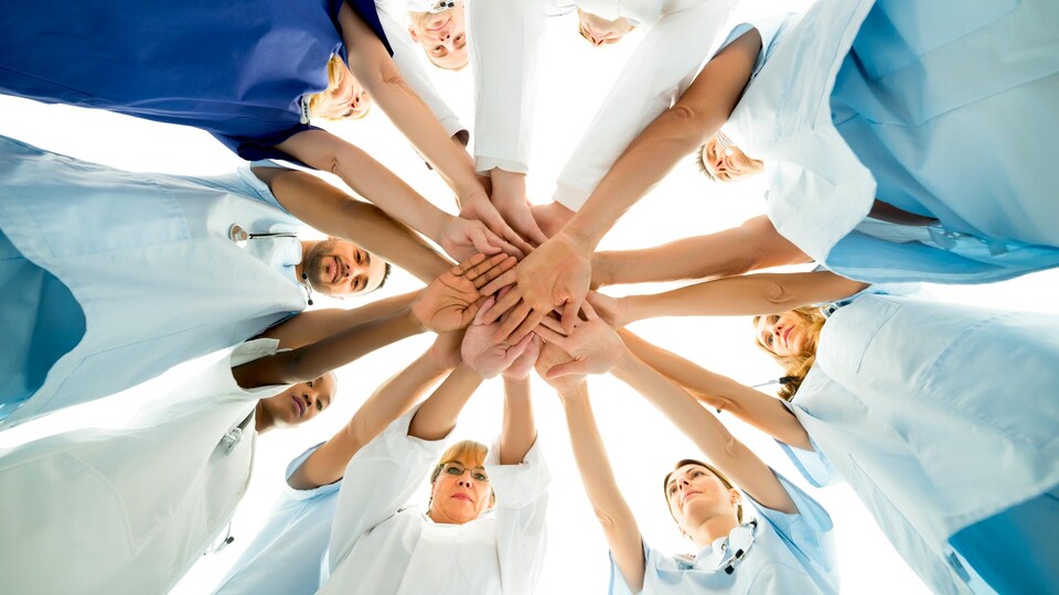 Des infirmières qui joignent leurs mains.