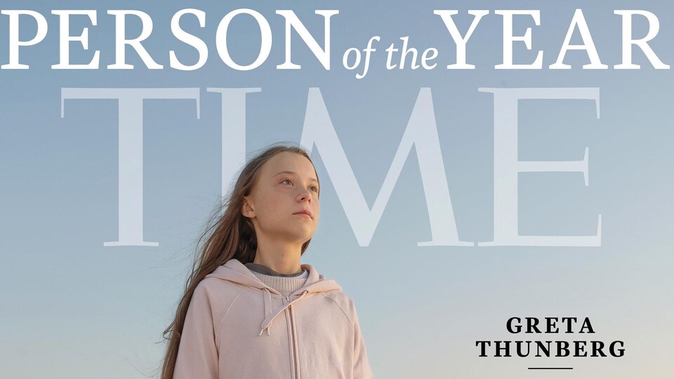 Greta Thunberg debout sur un rocher près de la mer.