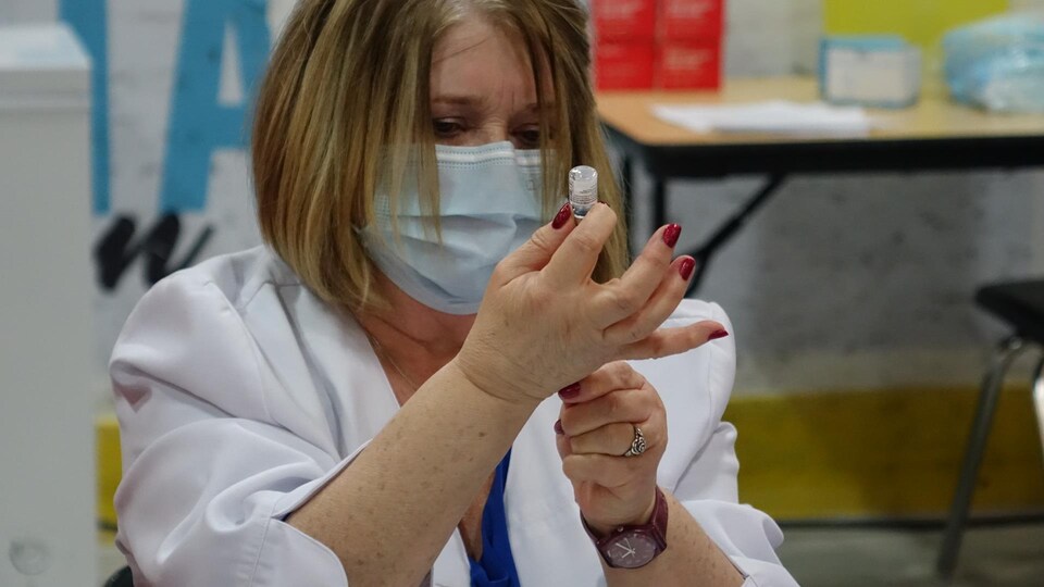 Une infirmière prépare une dose de vaccin contre la COVID-19, le 11 mars 2021 à Matane.