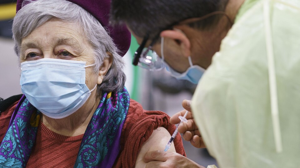 La femme se fait vacciner sur le bras.