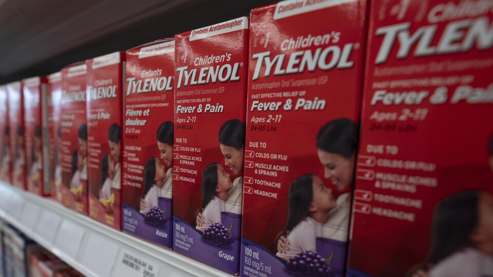 Gros plan de boîtes de Tylenol à saveur de raisin pour enfants sur la tablette d'une pharmacie.