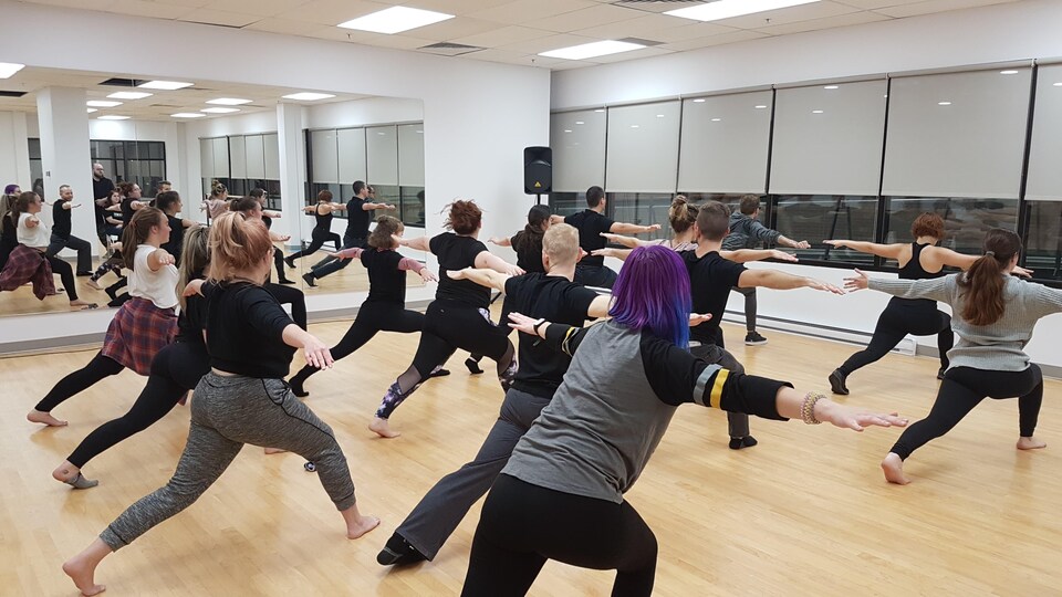 Des gens font des exercices dans un studio de danse