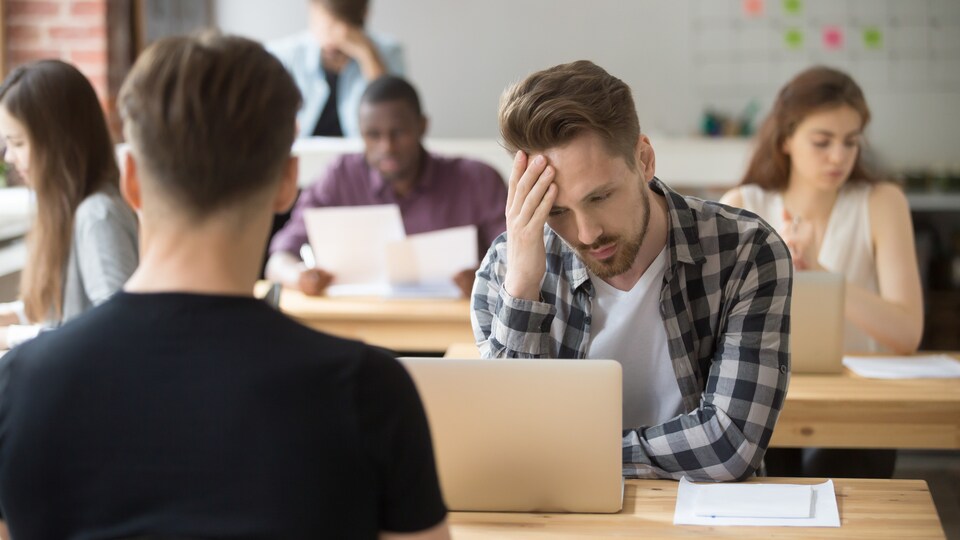Un homme se touche le front parce qu'il souffre de migraine.