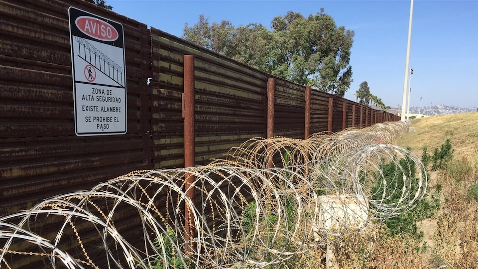 Un mur et des barbelés le long de la frontière entre les États-Unis et le Mexique