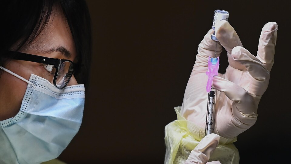 Une travailleuse de la santé remplit une seringue du vaccin de Pfizer-BioNTech.