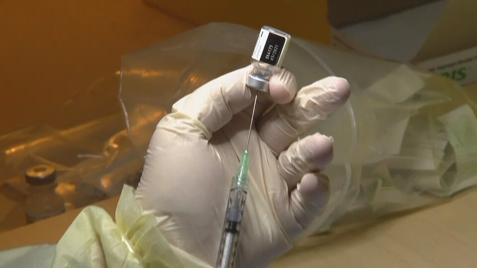 Une travailleuse de la santé tient une seringue contenant le vaccin.