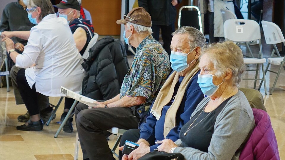 La vaccination contre la COVID-19 est en cours sur la Côte-Nord. Des personnes aînées en attente avec un masque.