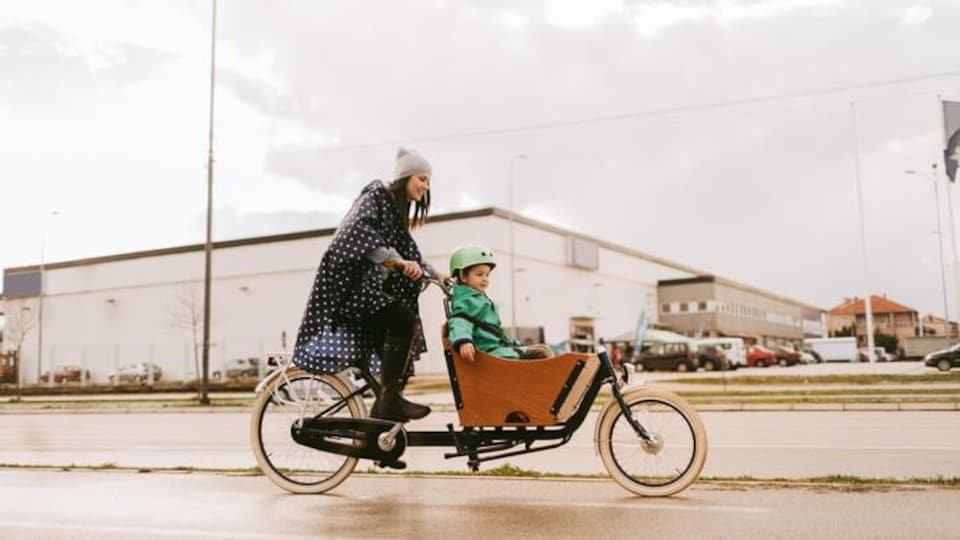 Une femme et son enfant sur un vélo cargo