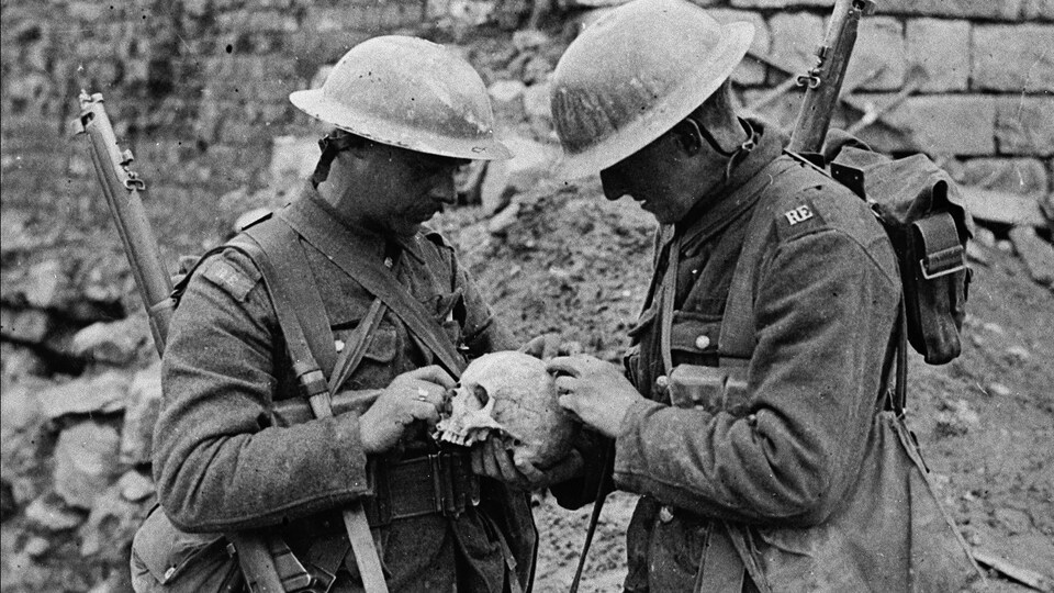 Deux soldats observent un crâne humain trouvé sur le champ de bataille de la crête de Vimy, en avril 1917.