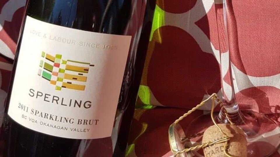 Une bouteille de vin sur une table et à côté, une coupe de champagne.