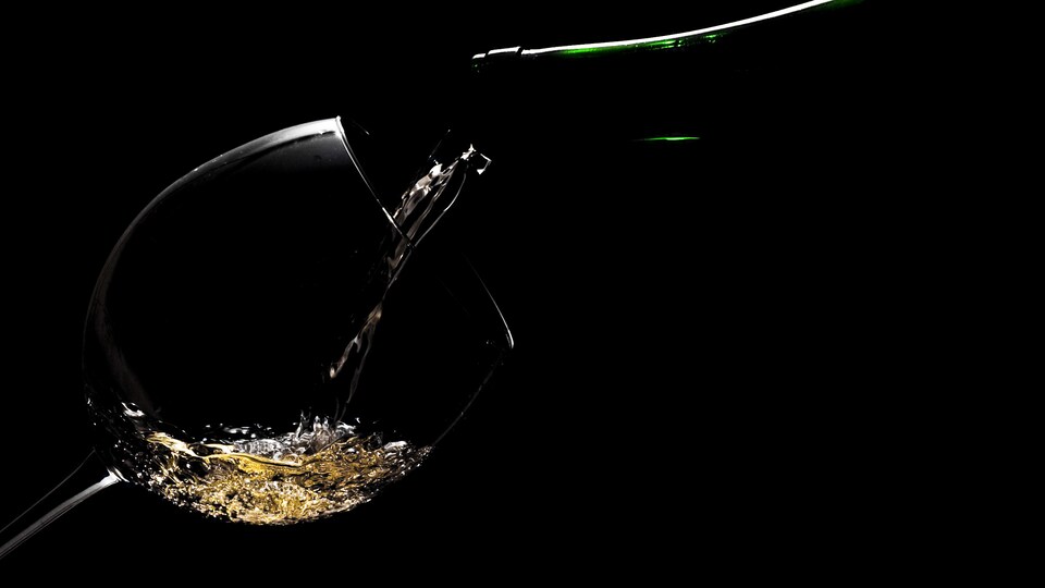 Un verre de vin légèrement éclairé sur fond noir