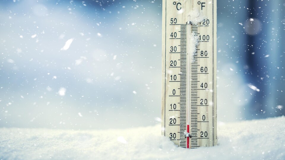 Un thermomètre à moitié enseveli dans la neige.