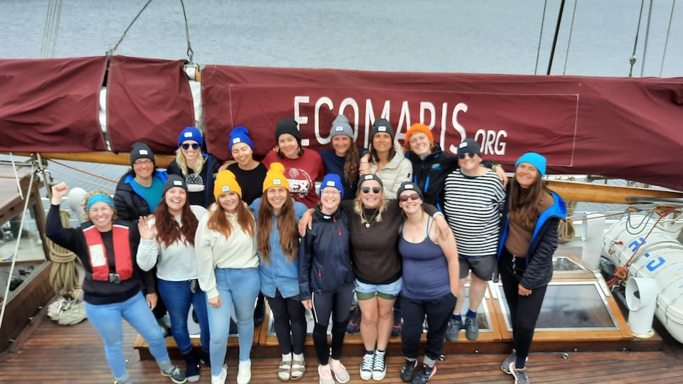 15 femmes souriant, sur un voilier