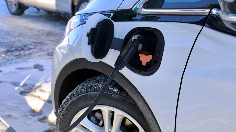 Gros plan sur l'aileron avant d'une Chevrolet Bolt lors d'une recharge, un jour d'hiver.
