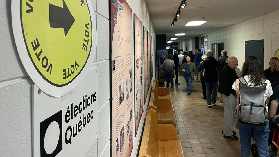 Une file d'électeurs attendent pour voter dans un bureau de scrutin.