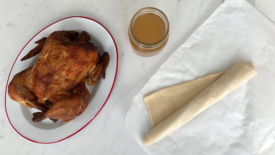 Un poulet rôti, un pot de bouillon de poulet et un rouleau de pâte feuilletée.