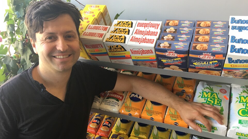 Felipe Recaman pose devant un étalage de produits latino américains.