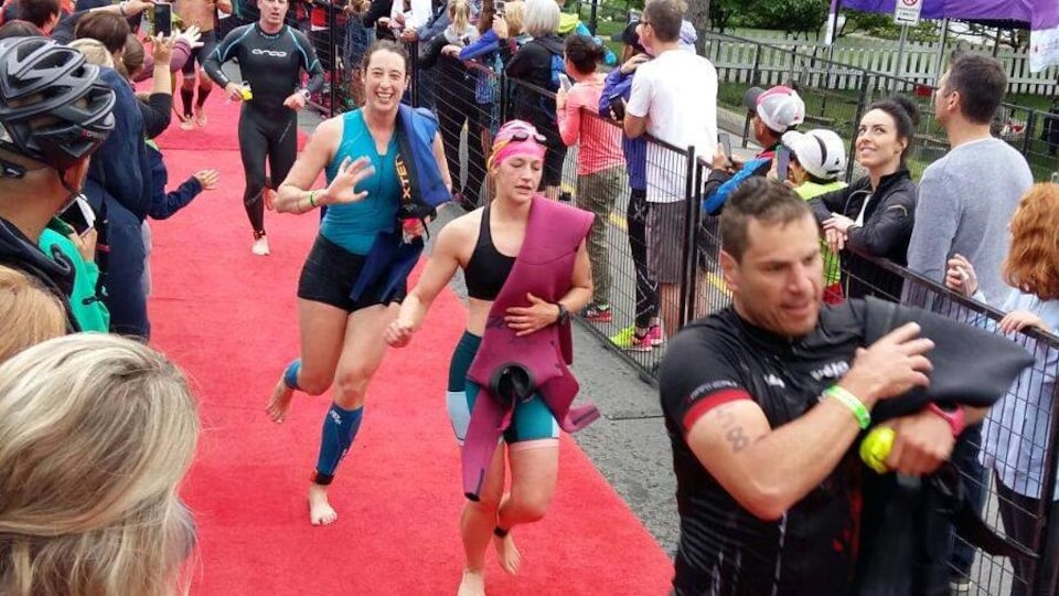 Marie-Hélène Ratel (en bleu) et d'autres participants au Ironman 70.3 de Mont-Tremblant courent sur un tapis rouge.