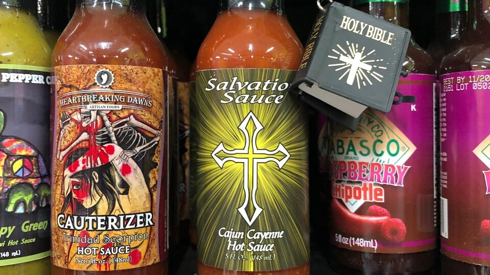 Un étalage de sauces piquantes artisanales dont la « Salvation Sauce » qui comprend une petite bible avec la bouteille.