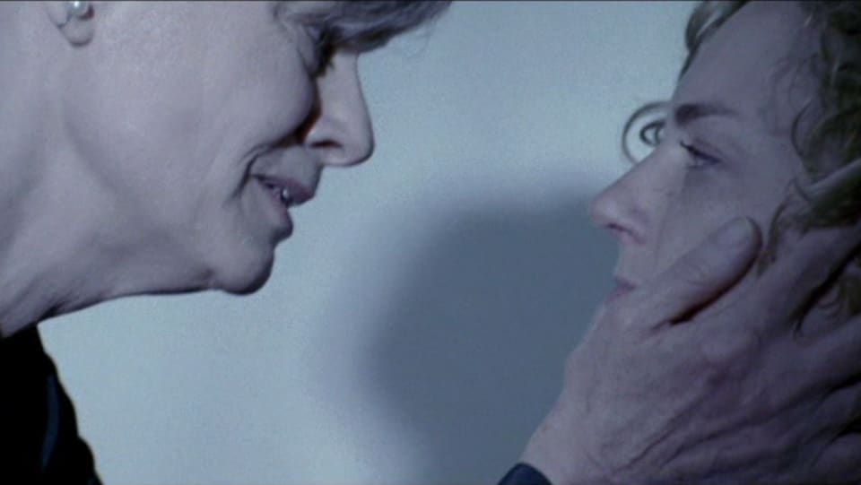 Une femme tient le visage d'une autre femme.