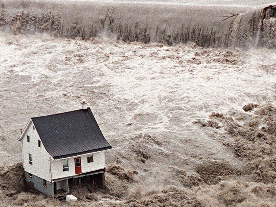 Une maison blanche au milieu des flots déchaînés.