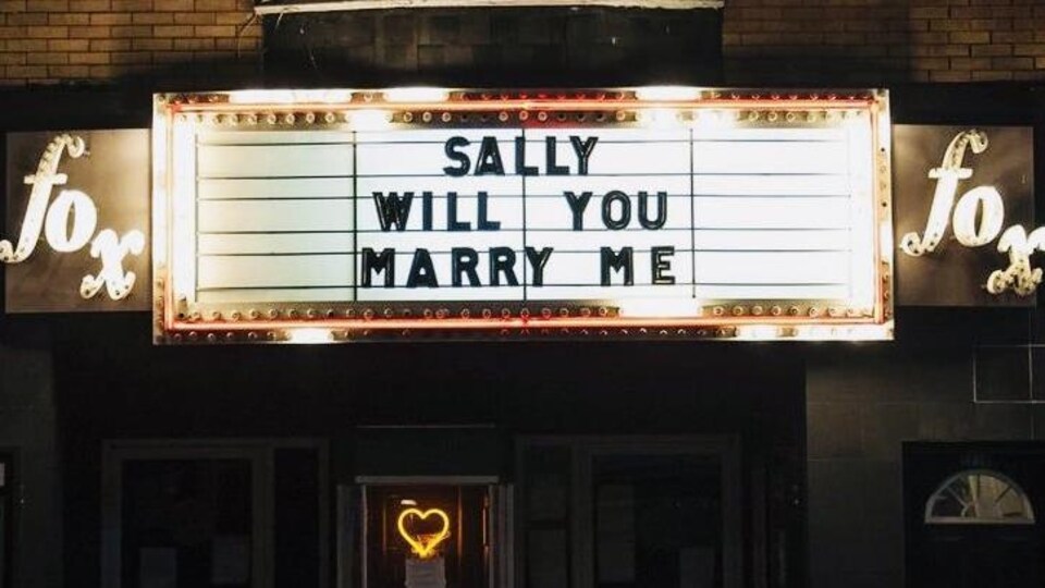 Le chapiteau du cinéma Fox sur la rue Queen à Toronto. On voit le chapiteau illuminé avec une annonce de noces.