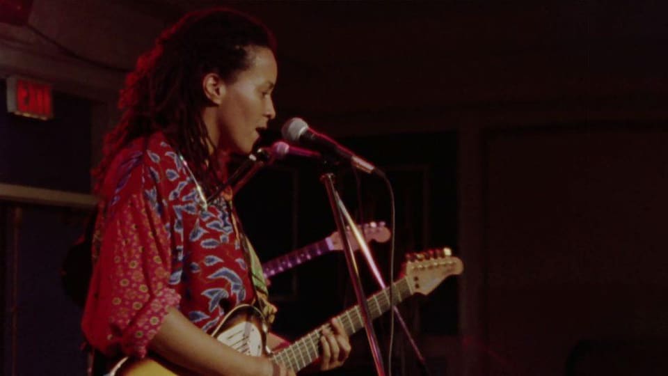 Image d'une guitariste dans le film Long Time Comin' de Dionne Brand.