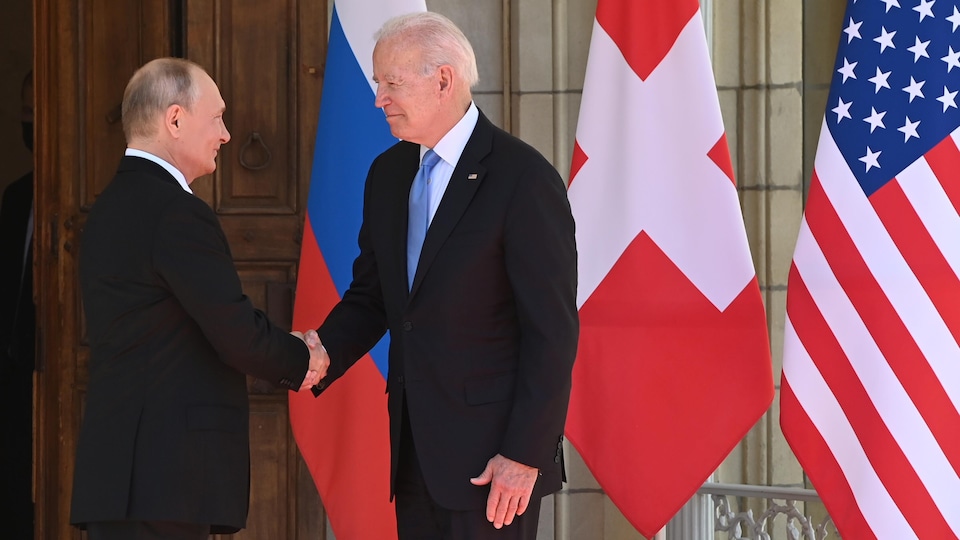 Vladimir Putin and Joe Biden shake hands.