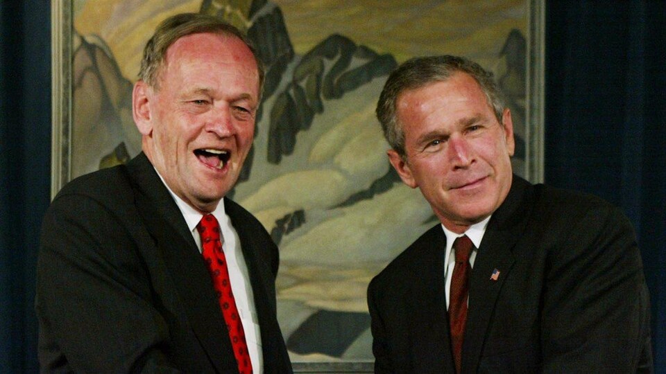 Jean Chrétien et George W. Bush posent en souriant.