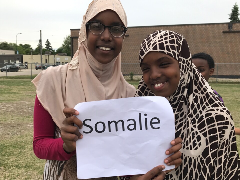 Deux jeunes filles d'une école primaire tiennent une affiche avec le mot ''Somalie'' qui affiche leur origine africaine