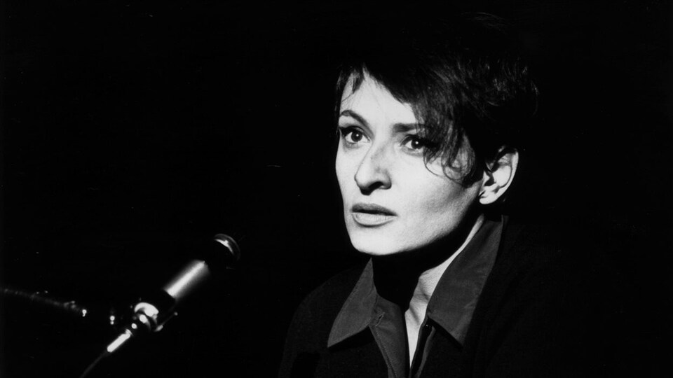 Un portrait de la chanteuse devant un microphone.