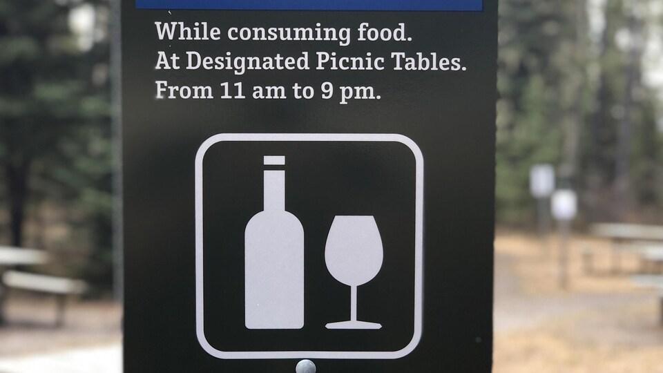 Panneau graphique d'une bouteille de vin et d'un verre indiquant qu'il est permis de consommer de l'alcool dans les endroits prévus à cet effet. 
