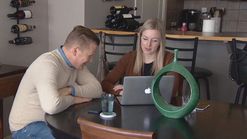Eric Slatter et Amanda Amyotte sont assis à une table et regardent un ordinateur ensemble.