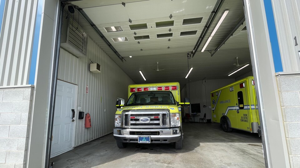 Deux ambulances stationnées dans un garage. 