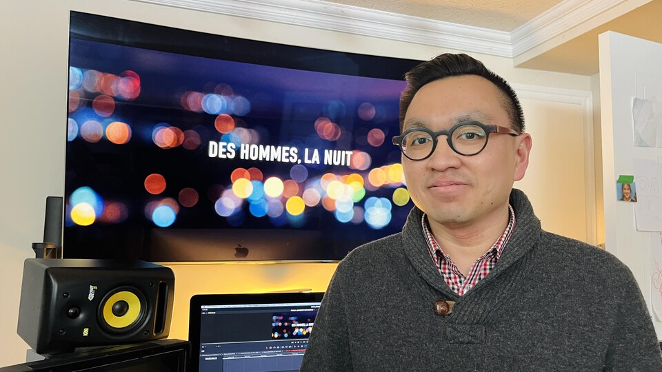 Anh Minh Truong devant un écran sur lequel est affiché "Des hommes, la nuit".