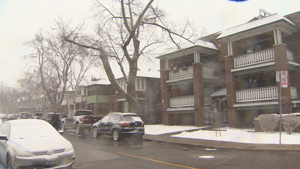 Un bloc de maisons dans une rue enneigée.
