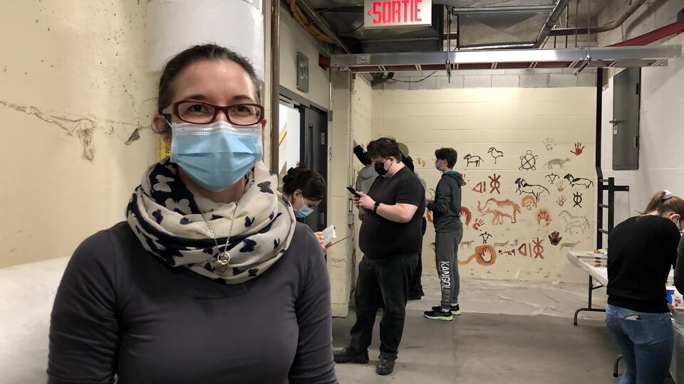 L'enseignante se trouve devant ses étudiants qui peignent.