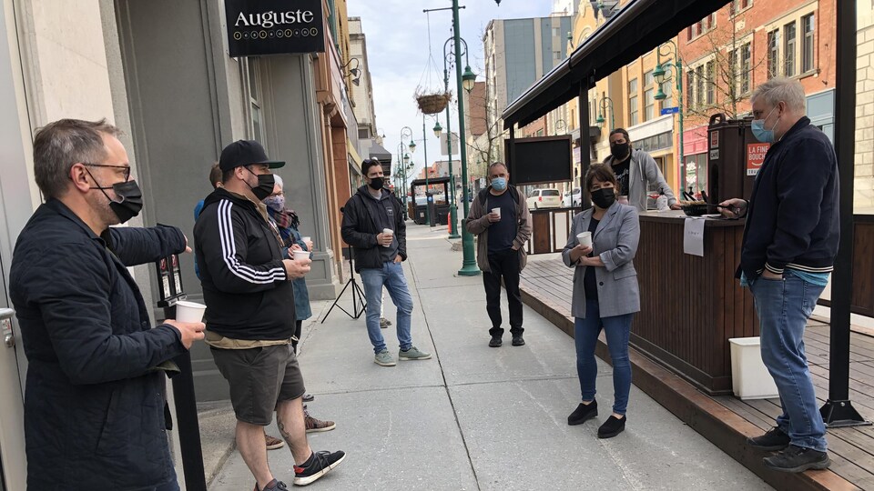 Une quinzaine de restaurateurs discutent, café à la main, devant le restaurant Auguste de Sherbrooke.