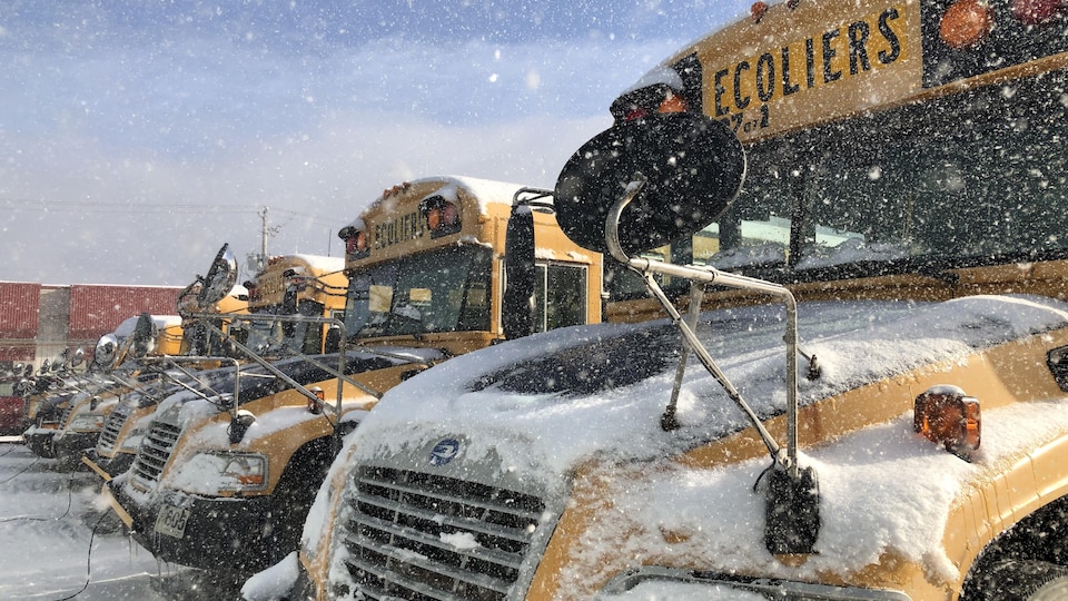 Des autobus scolaires dans la neige. 