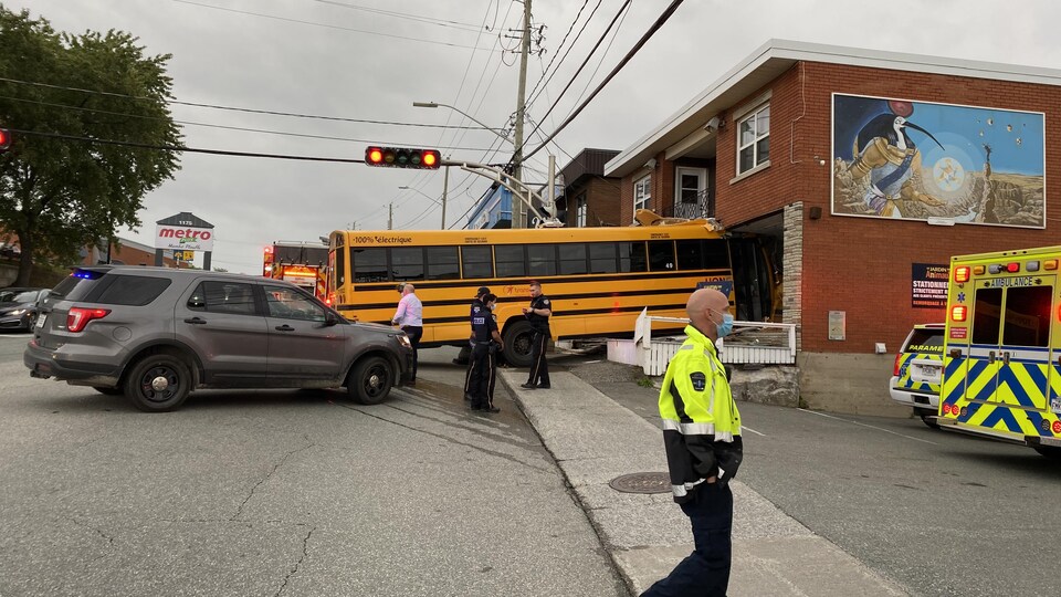 Un autobus scolaire est rentré de quelques mètres dans un édifice. 