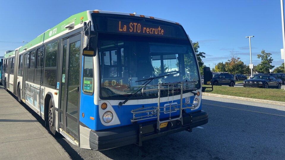 Un autobus de la Société de transport de l'Outaouais sur lequel il est indiqué « La STO recrute ».