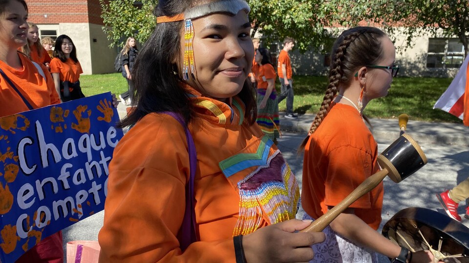 Une jeune femme autochtone participe à une manifestation. 
