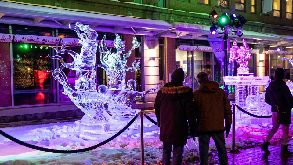 Des personnes qui admirent des sculptures de glace sur la rue Sparks à Ottawa.