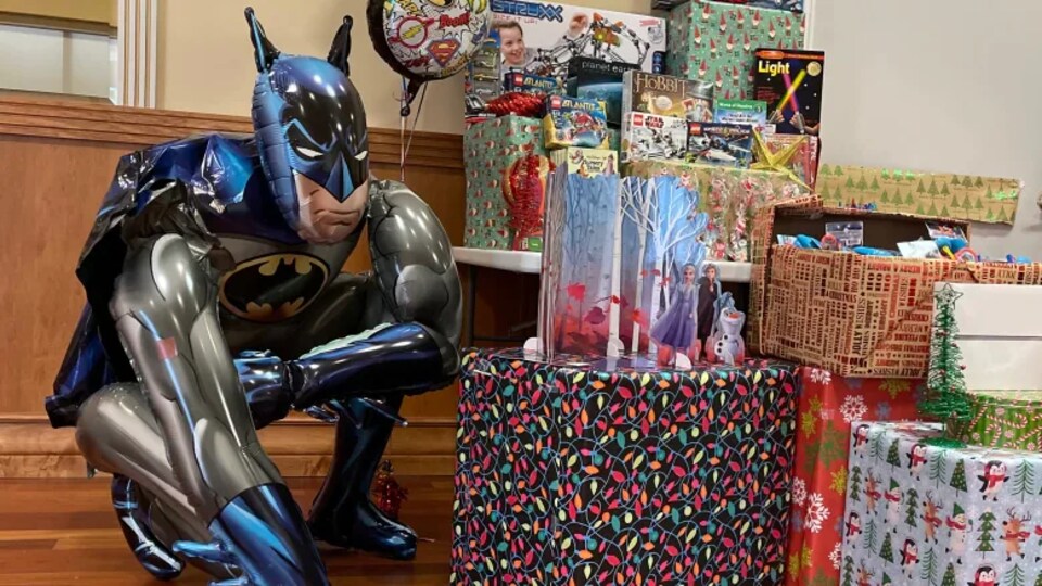 Une pile de cadeaux et une figurine géante de Batman.
